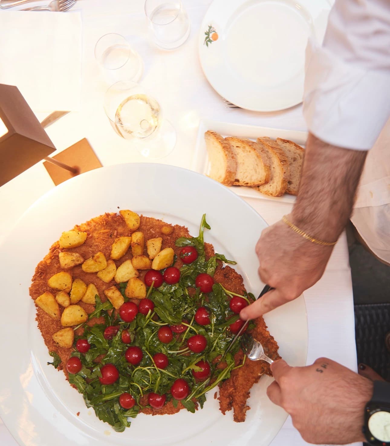Schnitzel paniert mit grissini, mit rucola und pomodorini