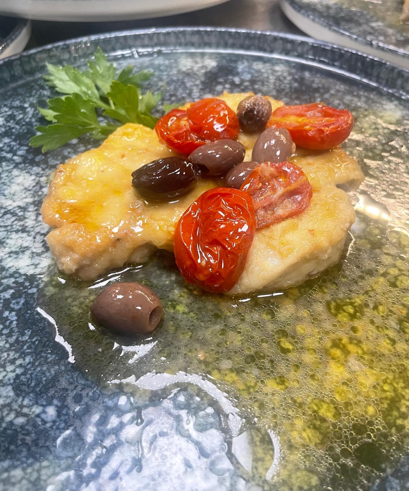 Bernsteinmakrelen-Scheibe mit vernaccia, Kirschtomaten und taggiasche
